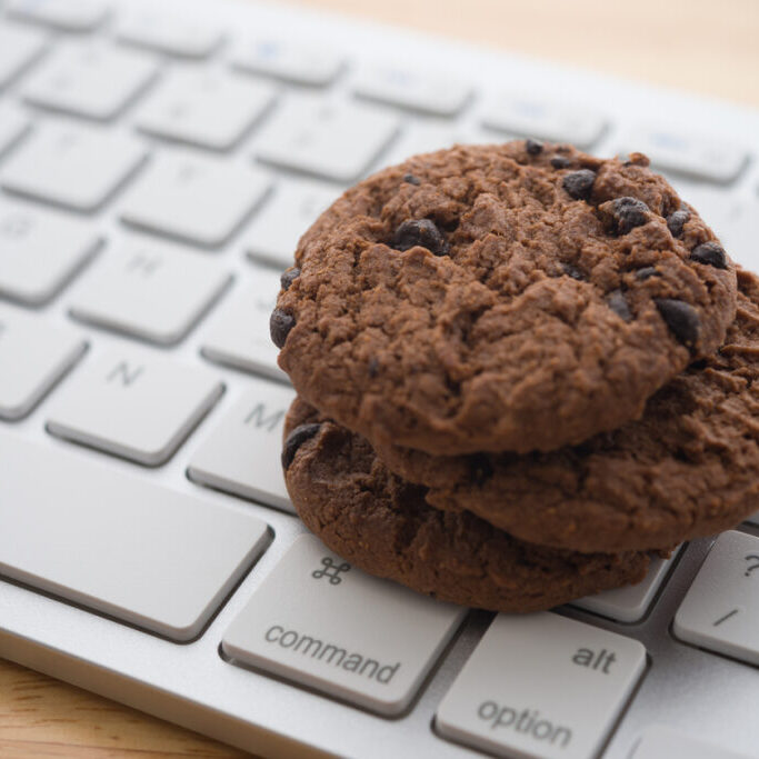 Chocolate chip cookies on keyboard computer background copy space. Cookies website internet homepage policy accpeted or blocks concept.