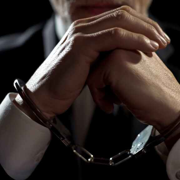 Upset handcuffed man imprisoned for financial crime, punished for serious fraud