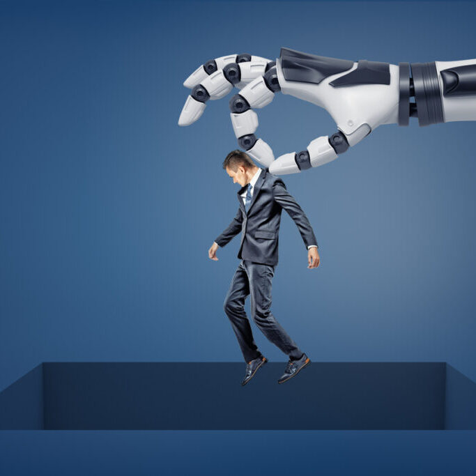 A giant robotic arm holds a small businessman over a large square empty opening in the floor. Business and technologies. Losing jobs in digital age. Bankruptcy and business closure.